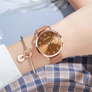 Close-up of rose gold watch with moon star dial and matching letter A charm bracelet