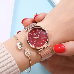 Gros plan détaillé de la montre en maille or rose avec cadran rouge et bracelet feuille