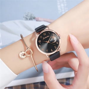 Close-up of women's black leather strap watch with moon dial and gold letter A bracelet