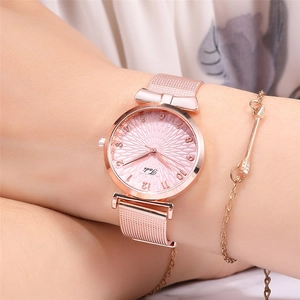 Close-up of rose gold mesh watch with pink sunray dial and elegant bow-shaped lug detail