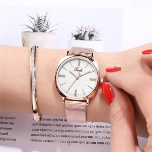 Close-up of rose gold watch with rhinestone markers and matching diamond-pave bracelet