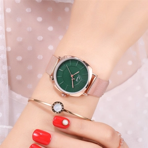 Close-up of elegant rose gold mesh watch with green dial, matching bracelet and ring