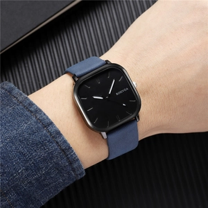 Gros plan d'une montre d'affaires carrée avec bracelet en cuir bleu et cadran noir