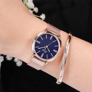 Rose gold women's watch with blue dial and matching crystal bracelet on a wrist