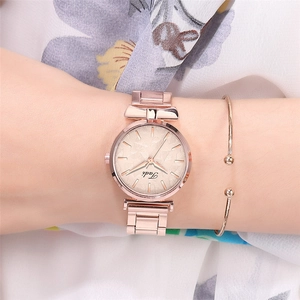 Close-up of rose gold watch with leaf pattern dial and matching bow bracelet set