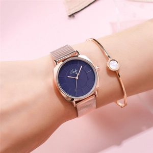 Close-up of elegant rose gold mesh watch with navy dial and matching jewelry bracelet