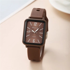 Macro shot of brown silicone strap and textured rectangular dial of quartz watch