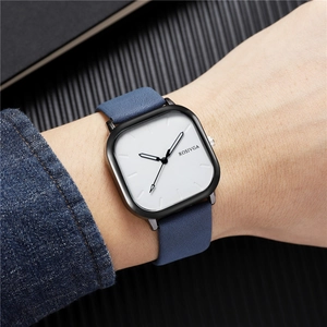 Gros plan d'une montre carrée avec cadran blanc et bracelet bleu portée au poignet