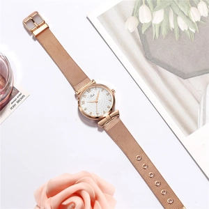 Close-up of Tadi rose gold mesh strap watch with a detailed sunray pattern dial