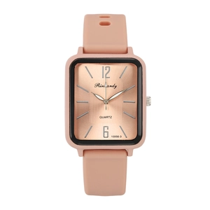Close-up of a rectangular rose gold watch face with soft pink silicone strap