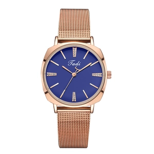 Detail of rose gold mesh strap watch featuring a navy blue dial with crystal accents