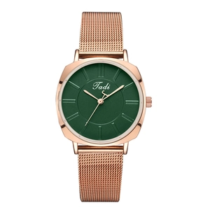 Close-up of rose gold mesh band and dark green dial with minimalist metal indexes