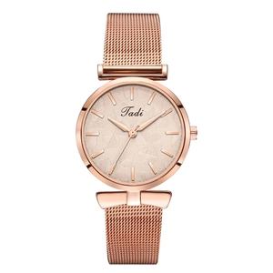 Détail de la montre à quartz or rose avec bracelet en maille et cadran à motif de feuille