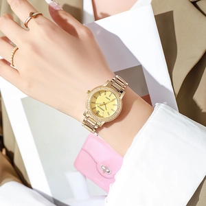 Détail d'une élégante montre à quartz dorée pour femme avec strass et bracelet métallique