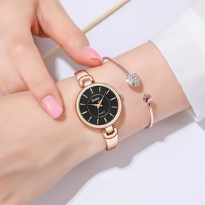 Gros plan d'une montre à quartz or rose avec cadran noir et bracelet coeur assorti