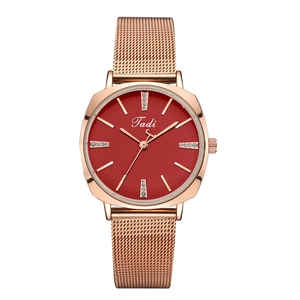 Detail view of rose gold mesh strap watch with a vibrant red dial and diamond markers