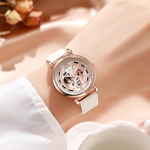 Détail d'une élégante montre squelette or rose avec bracelet en cuir blanc au poignet