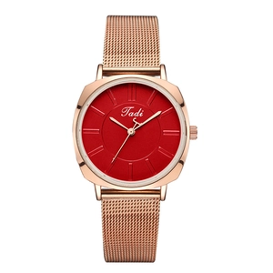 Detail of rose gold mesh band watch with minimalist red rectangular dial and Tadi logo