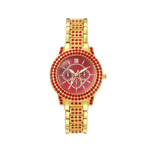 Détail d'une montre dorée pour femme avec lunette en cristal rouge et chiffres romains