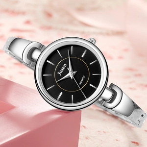 Détail d'une montre bracelet en acier argenté avec cadran noir et anneau doré
