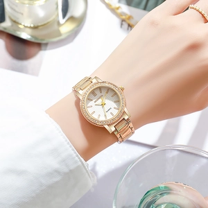 Gros plan d'une montre à quartz élégante en or rose avec une lunette sertie de strass brillants