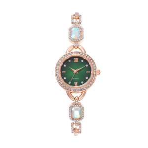 Detail of rose gold quartz watch featuring green sunray dial and colorful crystal accents