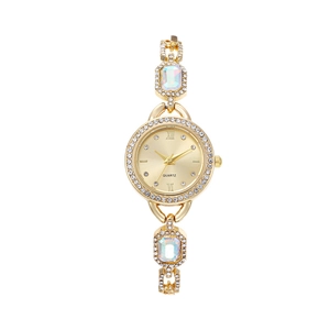 Detailed close-up of a gold quartz watch with rhinestones and opal-style stone accents