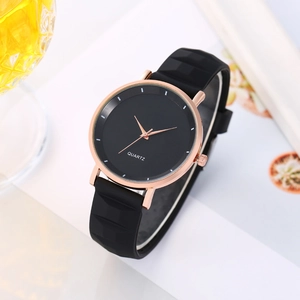 Dettaglio orologio al quarzo con cassa in oro rosa e cinturino in silicone nero su bianco