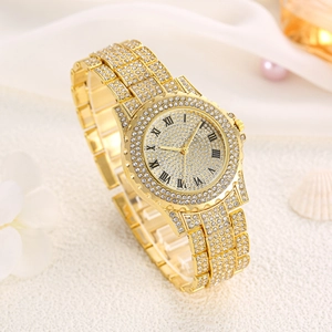 Montre à quartz dorée pour femme avec strass et chiffres romains sur un socle texturé