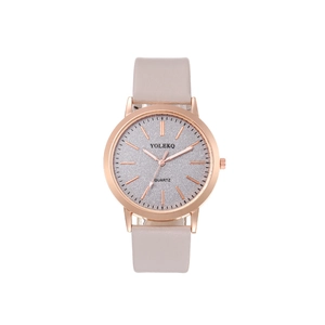 Detail shot of a rose gold quartz watch with a grey dial and light pink leather strap
