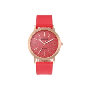 Detail of rose gold watch face with red glitter texture and leather strap