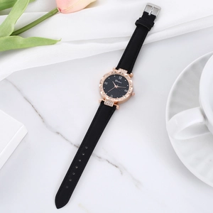 Montre quartz femme or rose avec cadran étoilé et bracelet cuir sur fond de marbre