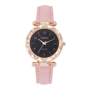 Détail d'une montre cadran étoilé or rose avec lunette en strass et bracelet en cuir rose