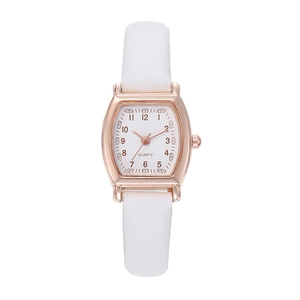 Detail view of tonneau rose gold watch case with quartz dial and white leather strap