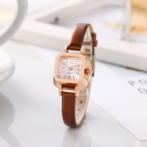Minimalist square rose gold watch with brown leather strap displayed on a white table