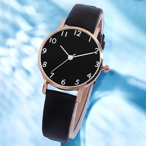 Close-up of leather strap and rose gold quartz watch case against a blue background
