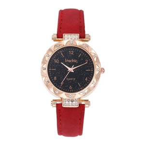 Détails du boîtier de montre or rose avec lunette en cristal et bracelet en cuir rouge
