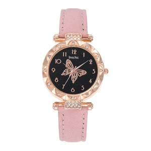 Detail of rose gold watch case with crystal bezel and embossed butterfly dial pattern