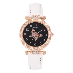 Detail of rose gold watch face with butterfly pattern and rhinestone bezel on white leather