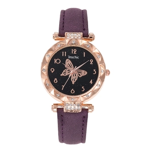 Close-up of women's watch with purple suede strap, rose gold case, and butterfly dial