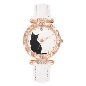 Close-up of rose gold cat watch with crystal bezel and white leather strap