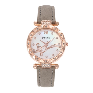 Close-up of rose gold watch case with crystal bezel and grey suede leather strap