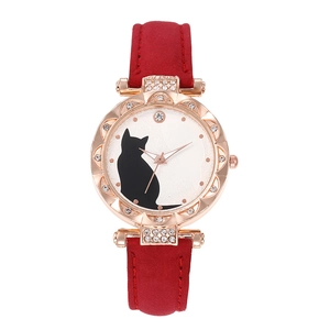 Detail of rose gold cat watch with rhinestone bezel and red leather strap on white dial