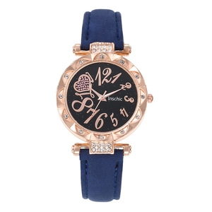 Détail d'une montre à quartz en or rose avec bracelet bleu marine et cadran ciel étoilé