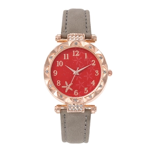 Macro detail of rose gold watch case with crystal bezel and floral red dial pattern
