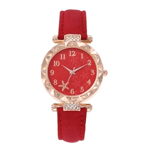 Close-up of rose gold watch with red dial, floral patterns and crystal bezel