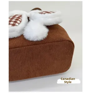 Detail showing the reinforced base of the brown corduroy bag with plush trim