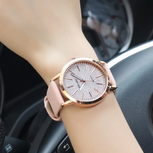 Women's quartz watch with frosted rose gold dial and pink leather strap worn on wrist