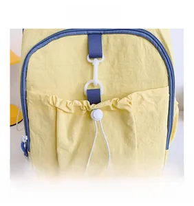 Detail of yellow nylon kids backpack with navy zipper and drawstring toggle pocket
