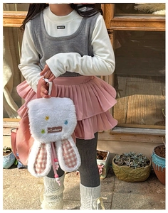 Close-up of plush kids backpack with pink plaid bunny ears and colorful star accents